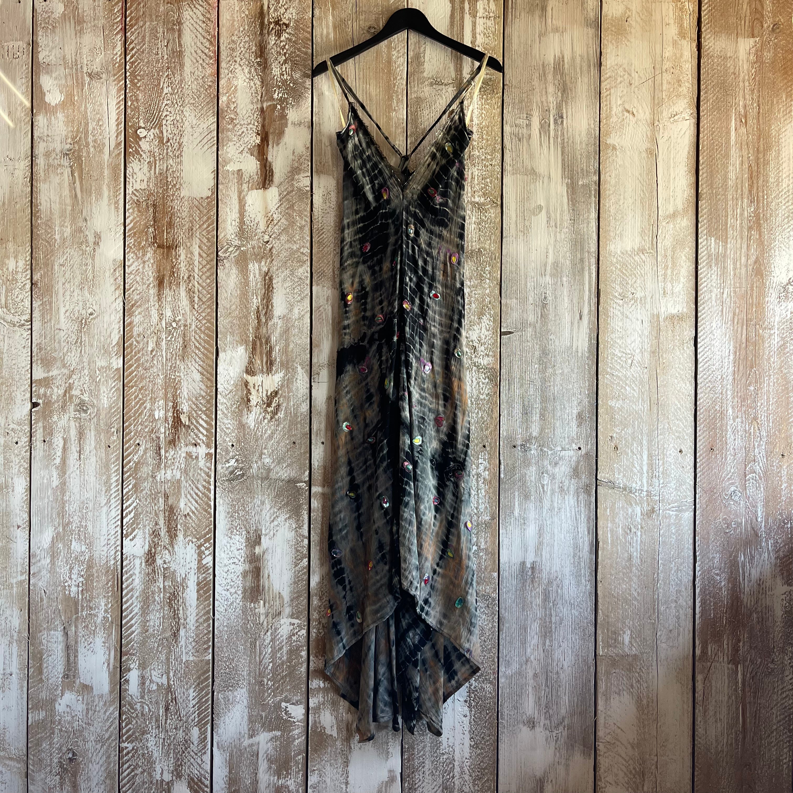 Black lace dress on a hanger against a wooden wall