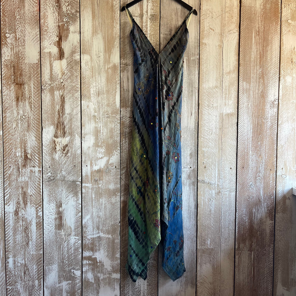 Multicolored dress hanging on a wooden panel wall