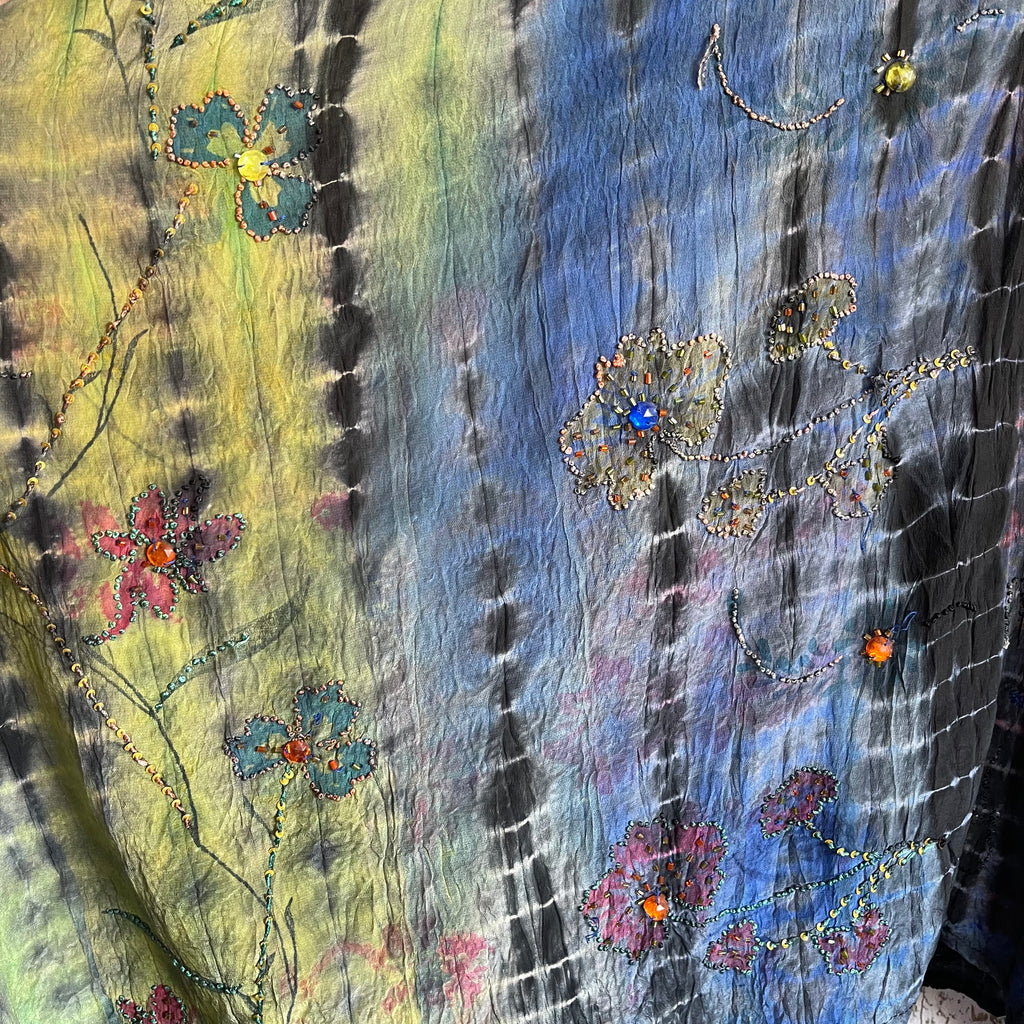 Textile with floral patterns and vibrant colors on a multicolored background