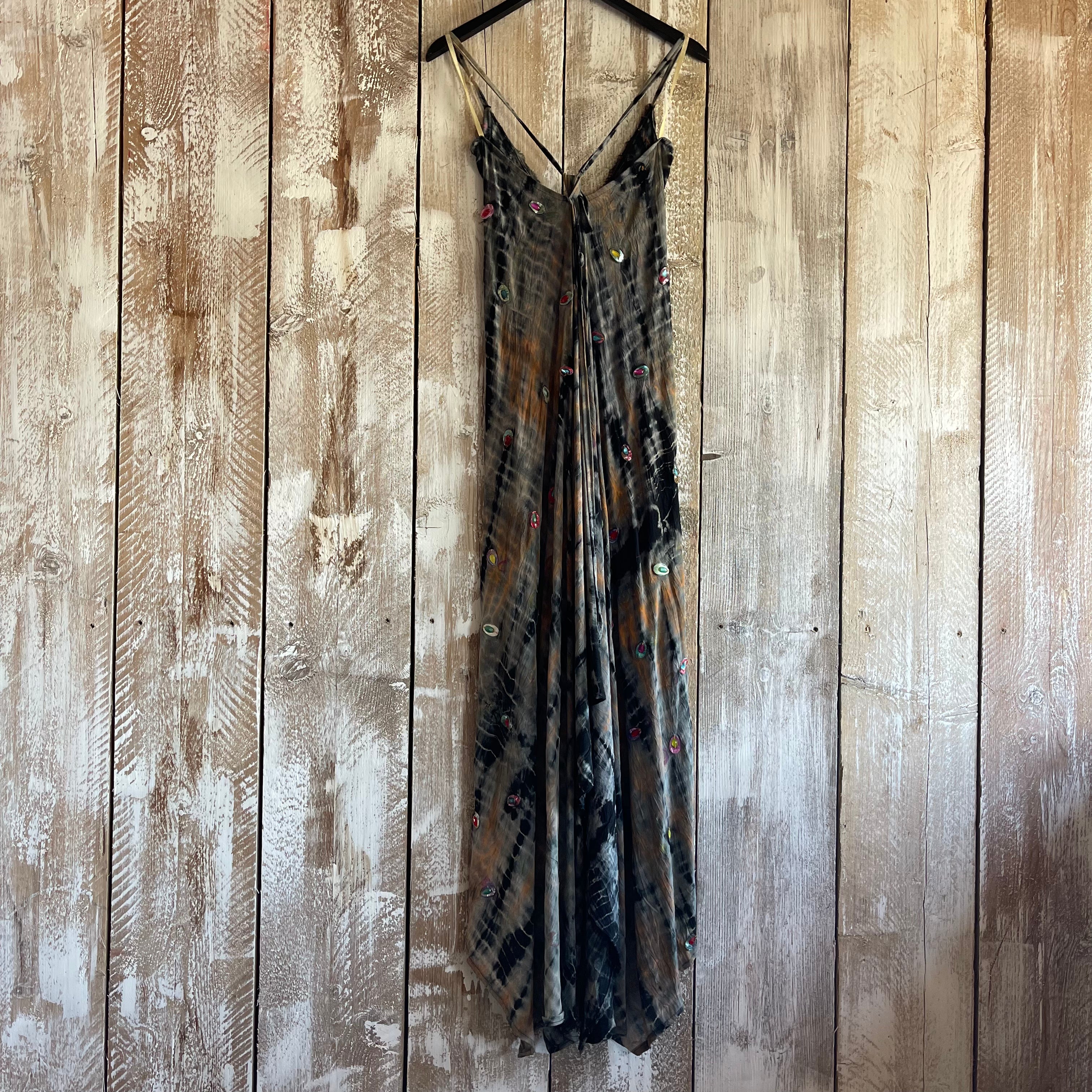 Long dress with floral patterns hanging on a wooden panel wall