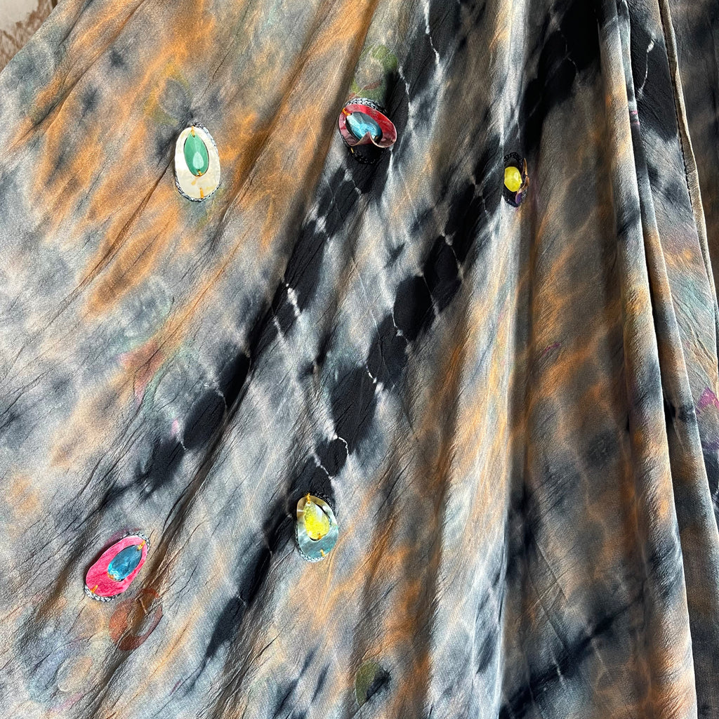 Colorful tie-dye pattern on a fabric with various colors including green, red, blue, and yellow.