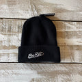 Black beanie with 'Be-RAD' logo on a wooden surface