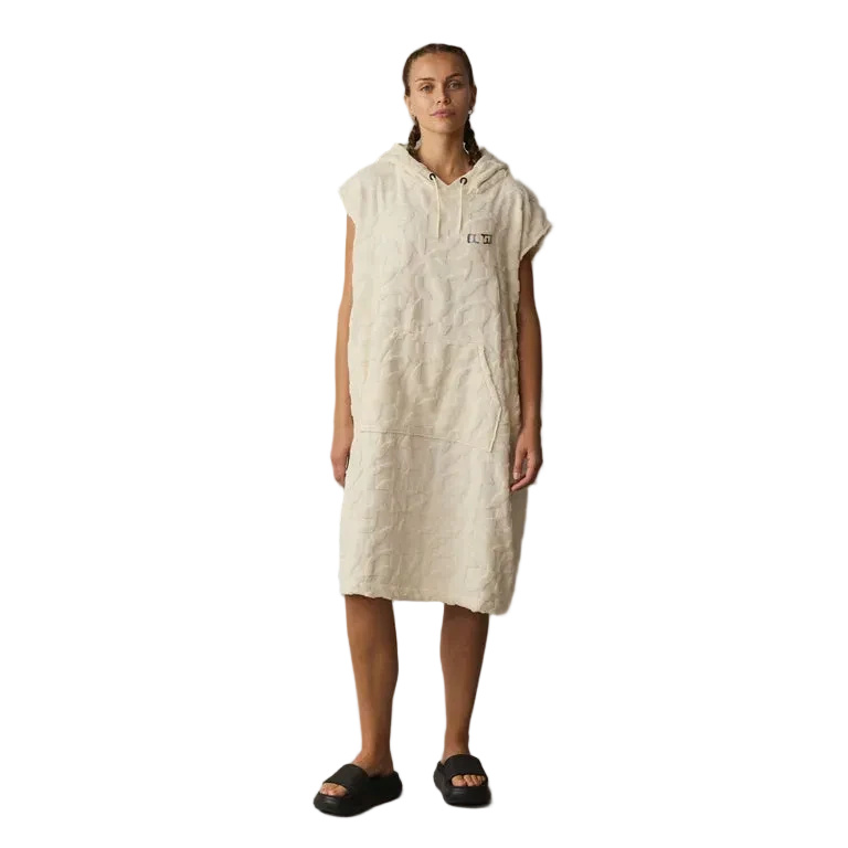 Person wearing a beige hooded dress against a gray background