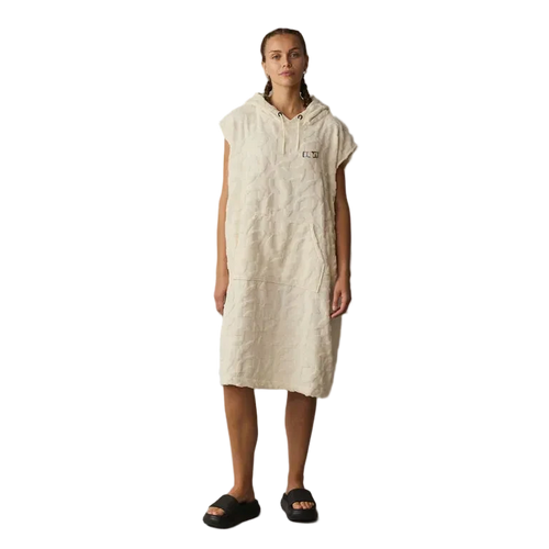 Person wearing a beige hooded dress against a gray background