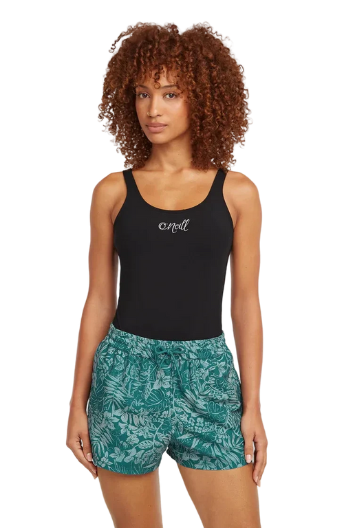Woman wearing a black tank top and green patterned shorts on a white background