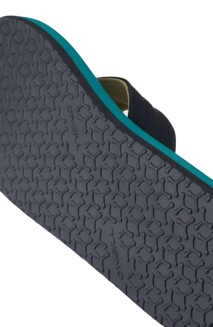 Close-up of a textured black sole with a green border on a light gray background