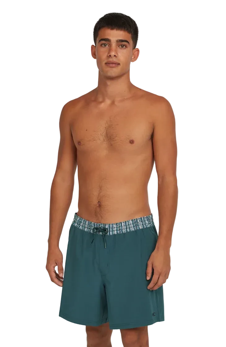 Man wearing teal swim shorts on a white background